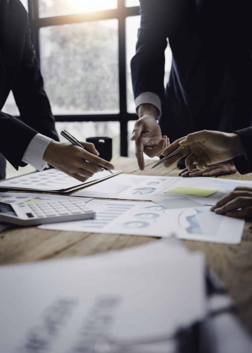 Businessmen meeting to plan, analyze, graph and chart business growth.